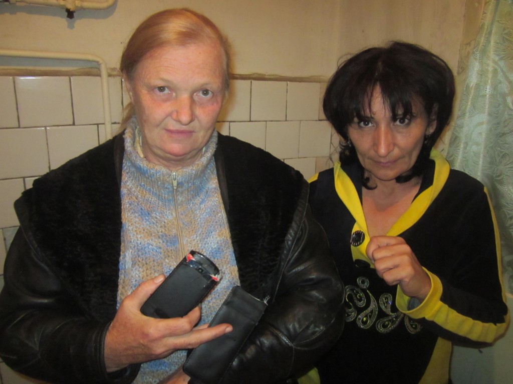 Елена Урлаева показывает поврежденный телефон, а Малохат Эшанкулова - разорванную кофточку. Это одно из немногих фото рейда, которые "Бесстрашным" удалось восстановить; фото: Елена Урлаева