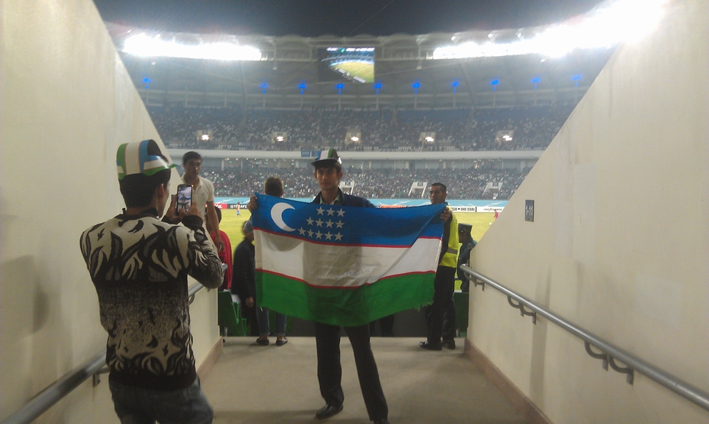 Узбекистанский болельщик держит государственный флаг; фото:Ц-1