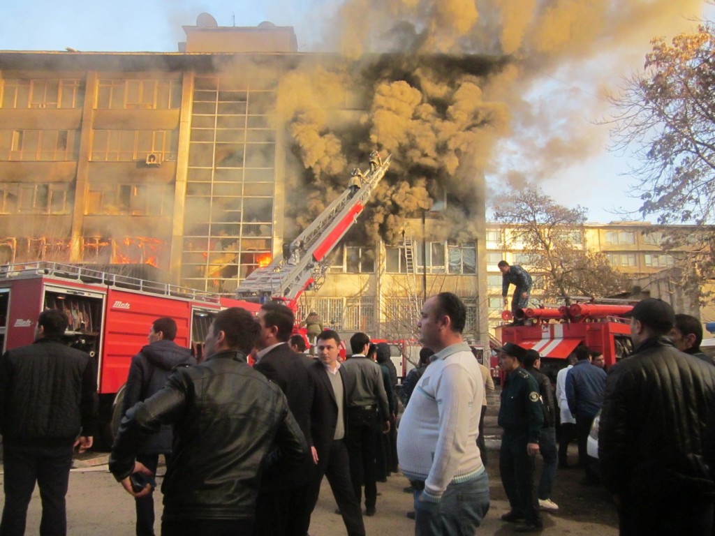 Дым почернел, но пожарники устремляются по лестнице в горящее здание; фото: Ц-1