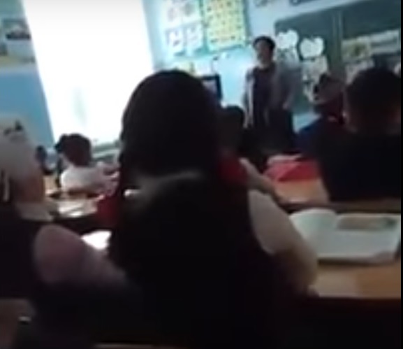 Скриншот из видео, снятого на мобильный телефон, на котором учительница бьет и оскорбляет детей