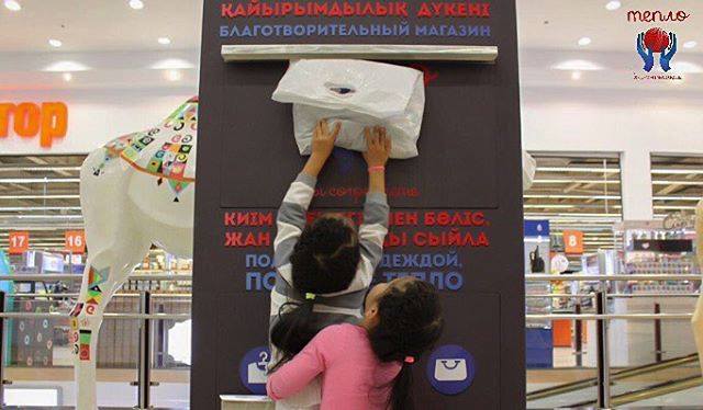 Дети пытаются отправить в контейнер пакет с теплой одеждой; фото: teplocharity.kz