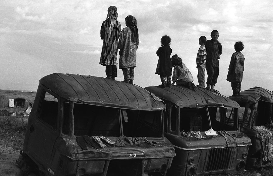 Таджикские дети стоят на сожженых во время войны грузовиках; фото: Виктория Ивлева, Русский Репортер