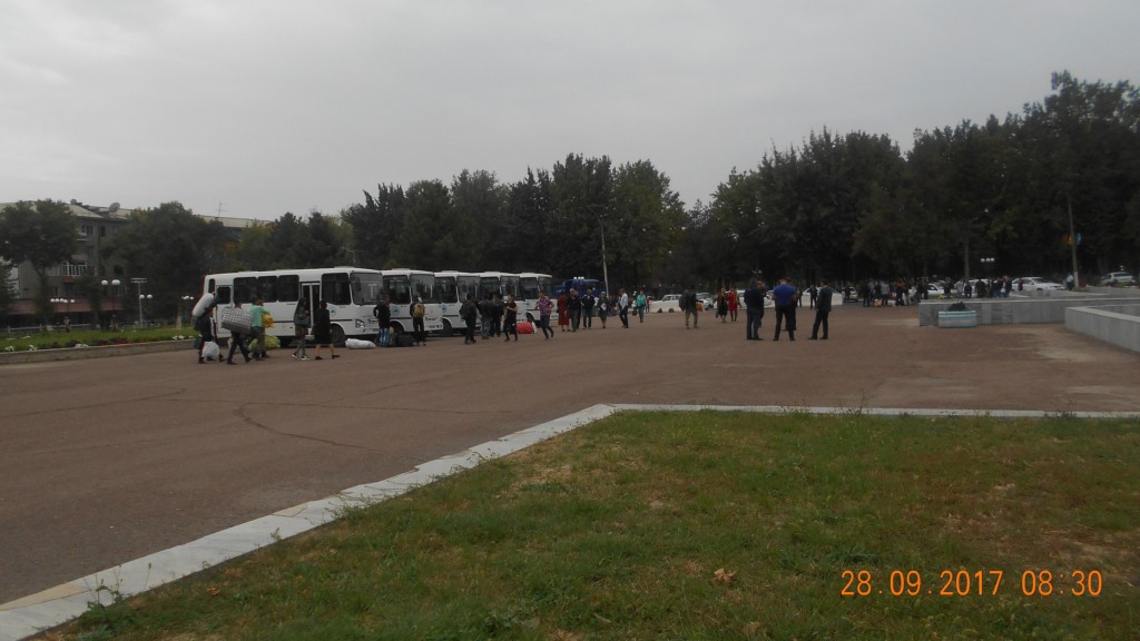 Автобусы готовятся к отправке, в стороне - сотрудники прокуратуры и хокимията Ангрена; фото: ПАУ