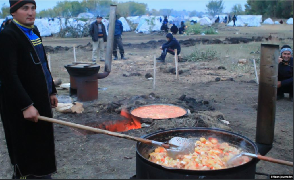 Узбекистанец готовит еду в лагере в Самарской области РФ; скриншот